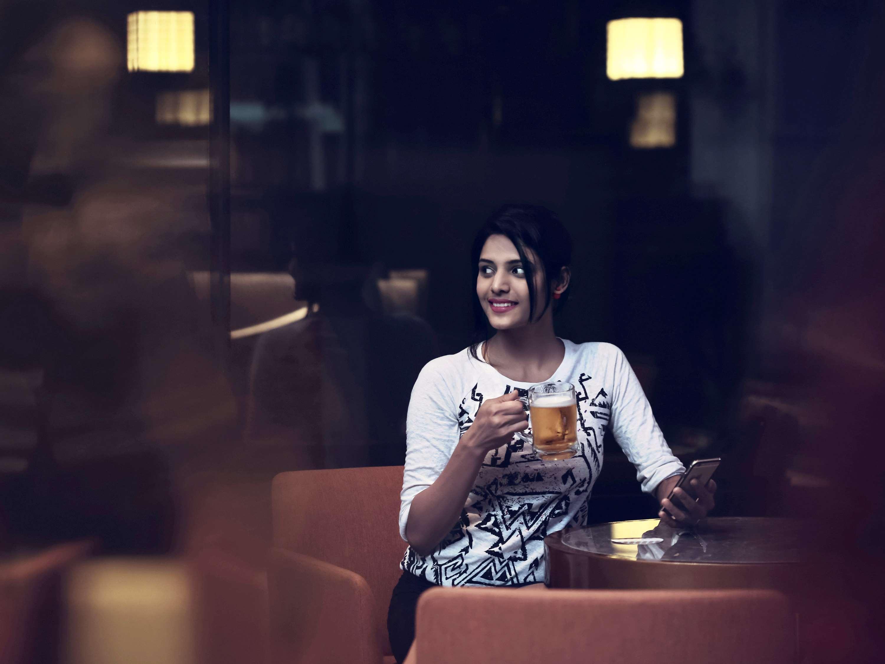 海得拉巴kcp雅高美居酒店 外观 照片 A woman drinking beer